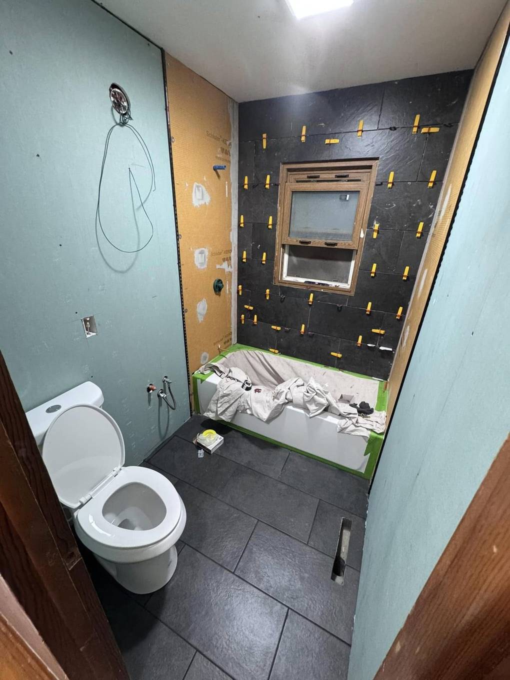 Slate wall tile around the window, toilet installed