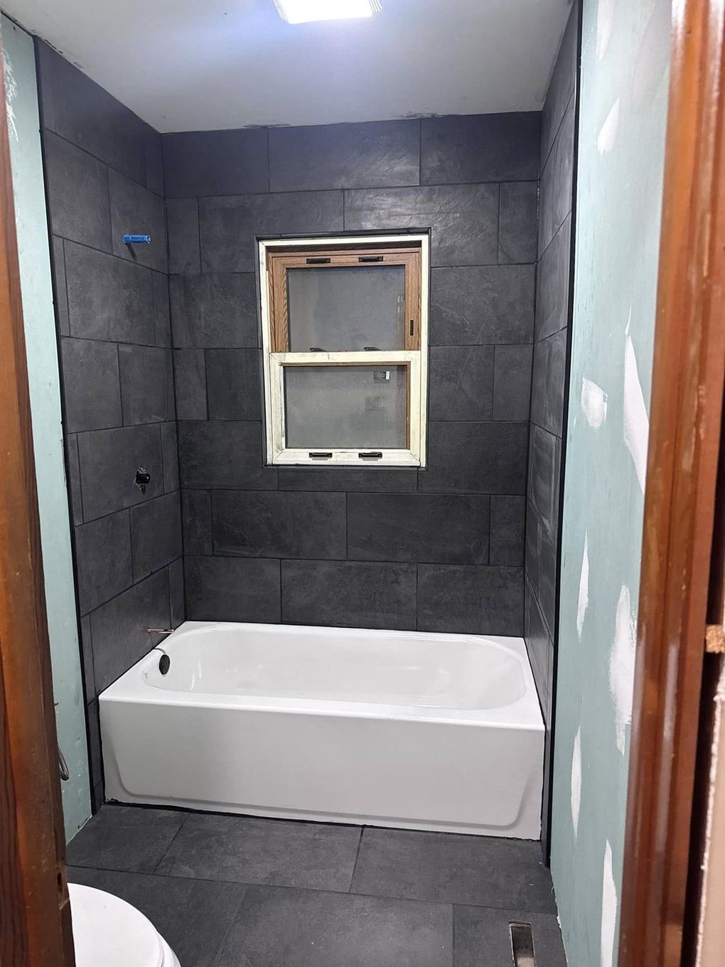 Finished dark slate tile tub and shower surround