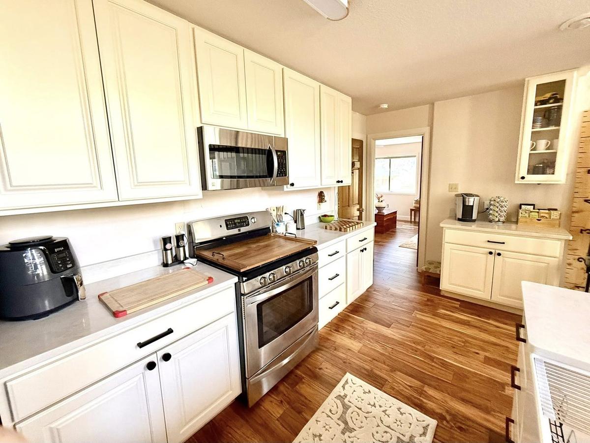 Rebuilt white kitchen with stainless range and wood floors