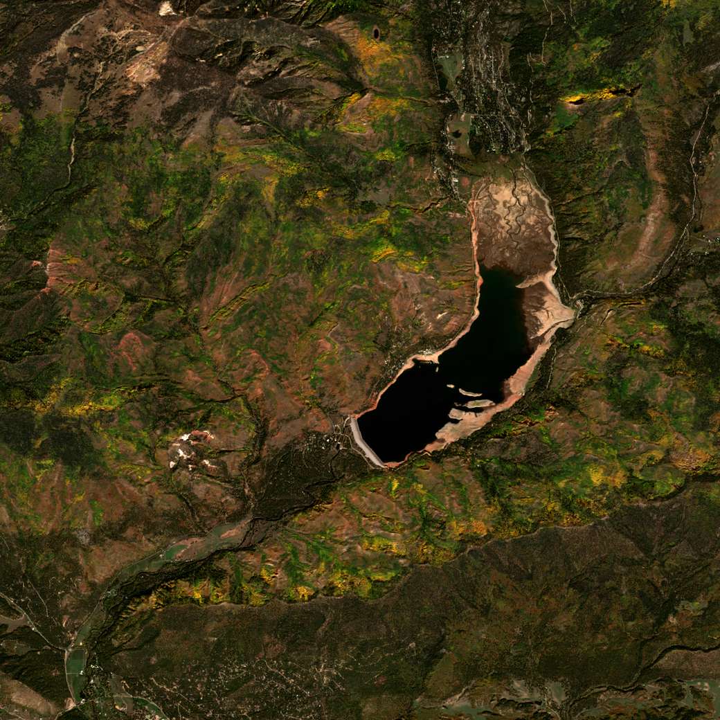 Satellite view of Vallecito Reservoir on October 7, 2025, the lake dark and drawn down to a low pool with pale exposed flats at its north inlet.