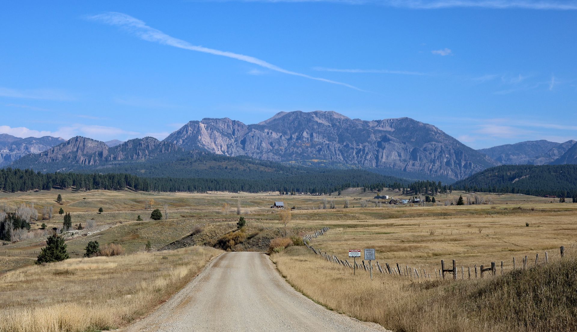 A dirt road crossing ranchland toward the San Juan Mountains near Piedra, Colorado