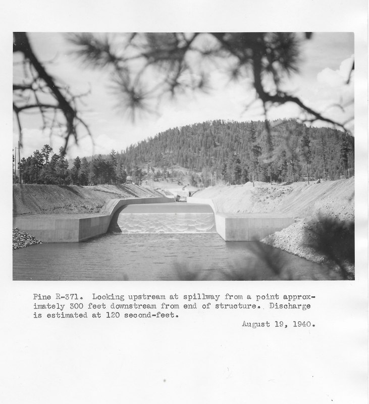 The Vallecito Dam spillway flowing during construction, discharge estimated at 120 cubic feet per second