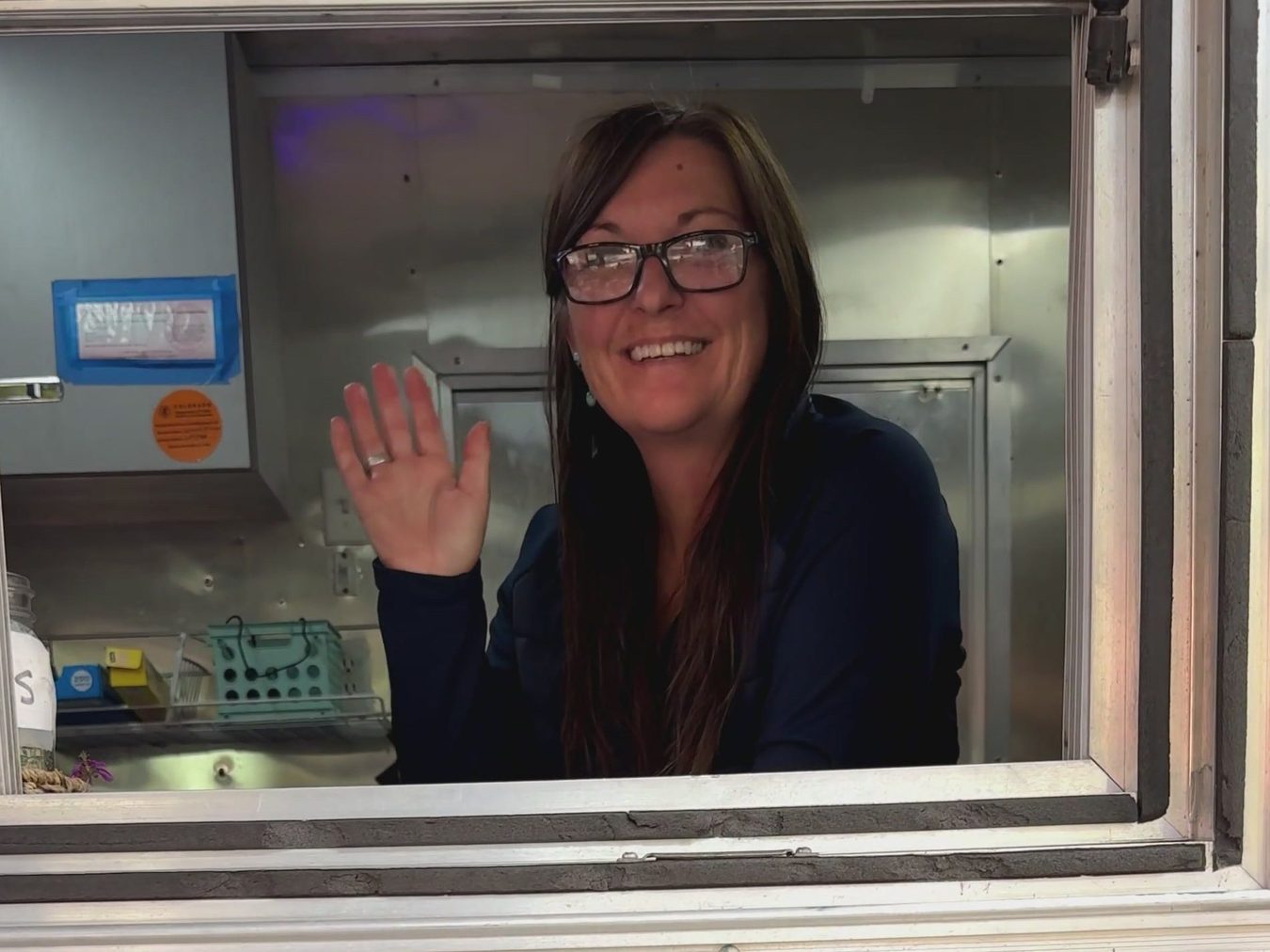 Aimee waving from inside the truck's service window